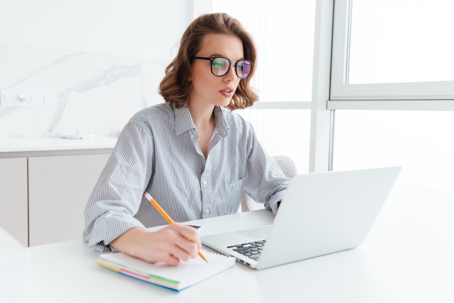 Young Concentrated Brunette Woman in Glasses